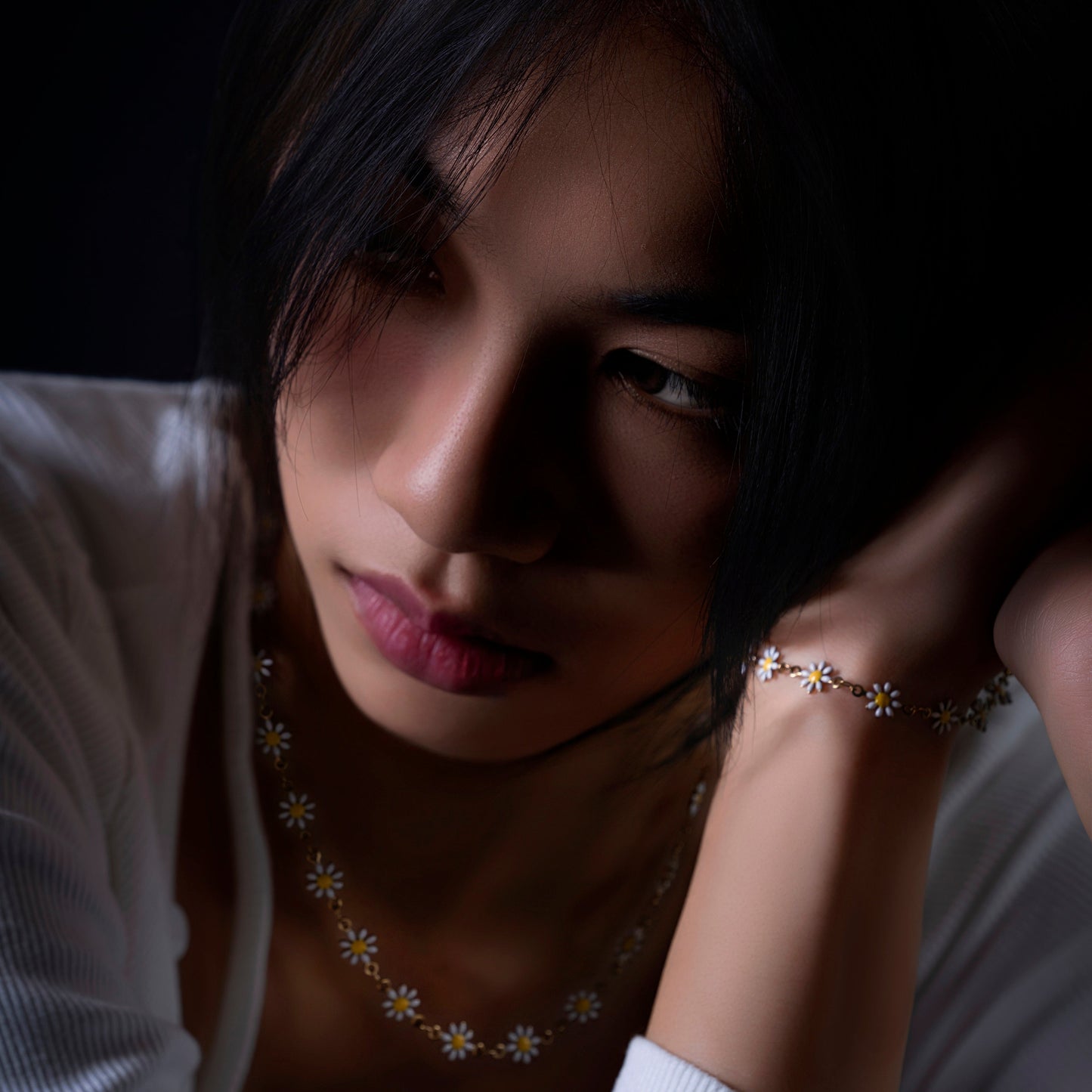 Close portrait of the Sunward daisy necklace and bracelet worn together