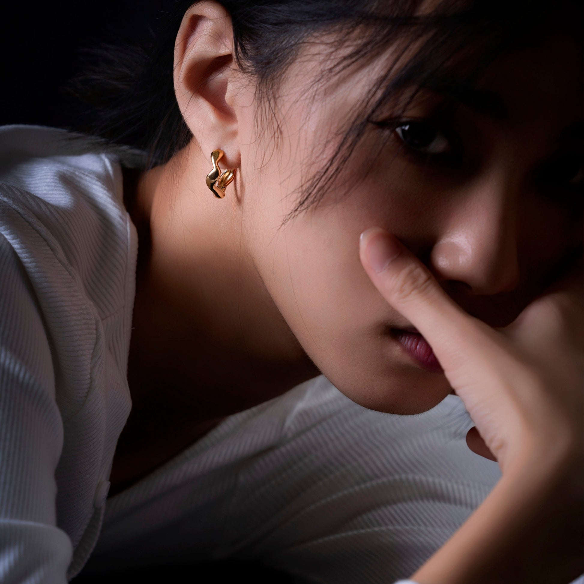 Flux organic gold huggie earrings worn by a model