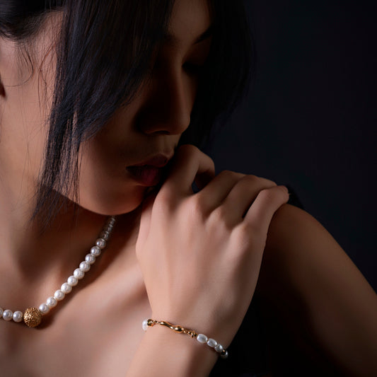 Model wearing the First Light pearl-look necklace and matching bracelet set by JUE & YUE